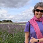 What is means to be Wellthy A smiling Julie standing in a field of flowers